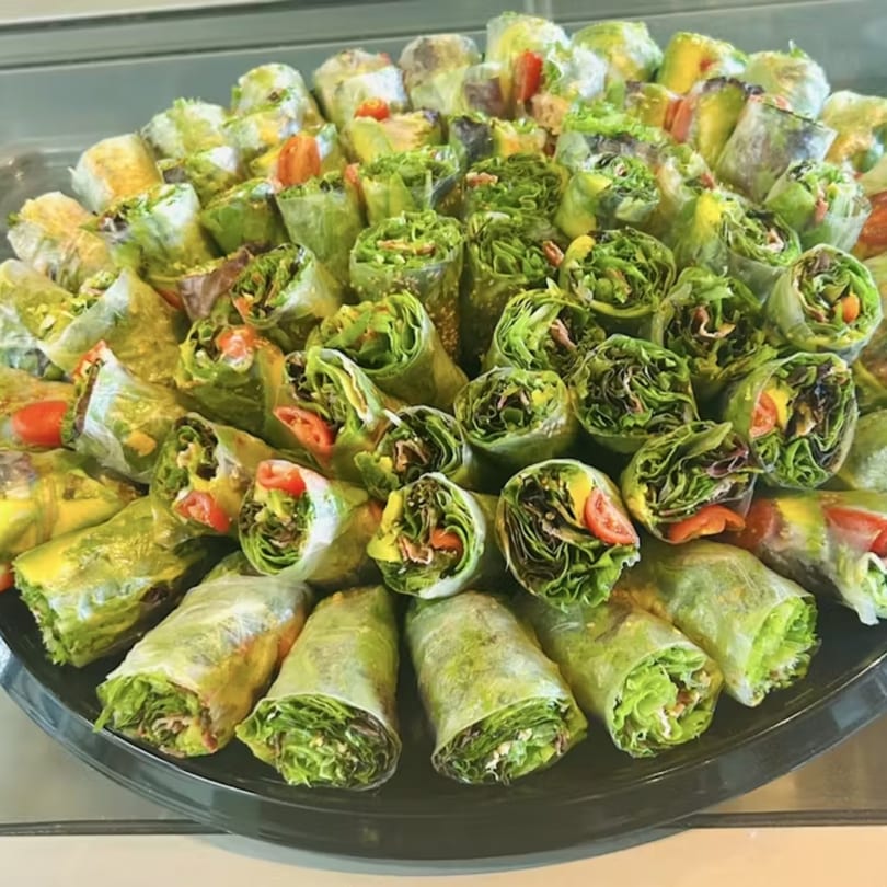 A platter of fresh Up Leaf Café spring rolls, filled with lettuce, tomatoes, and other vegetables.